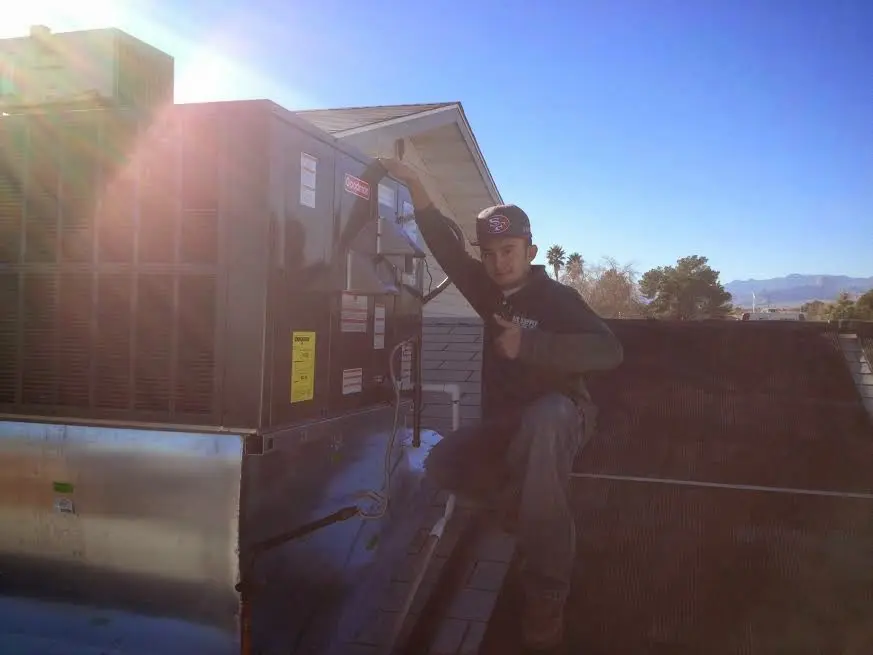 HVAC technician performing Boiler Repair on a rooftop unit in Pulaski