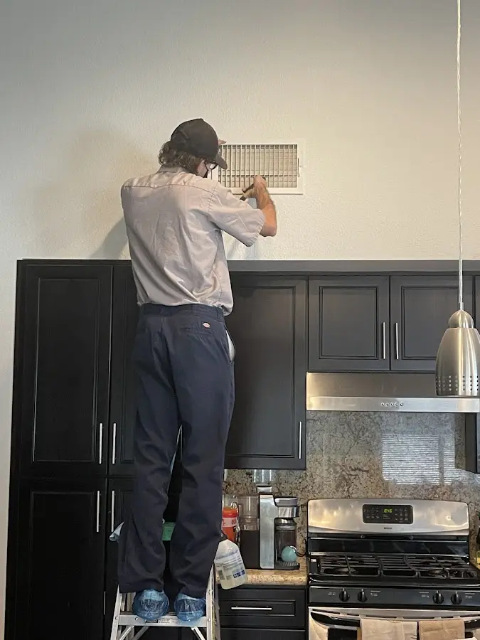 Technician inspecting an air vent during HVAC service in Pulaski